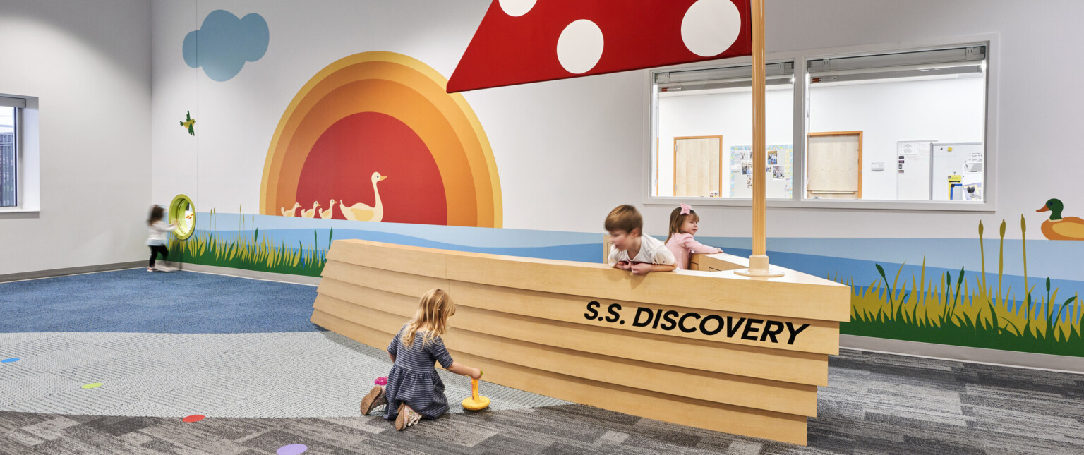 North Kansas City School Early Education Center interior. An interactive boat play area with red sail, graphic murals on wall