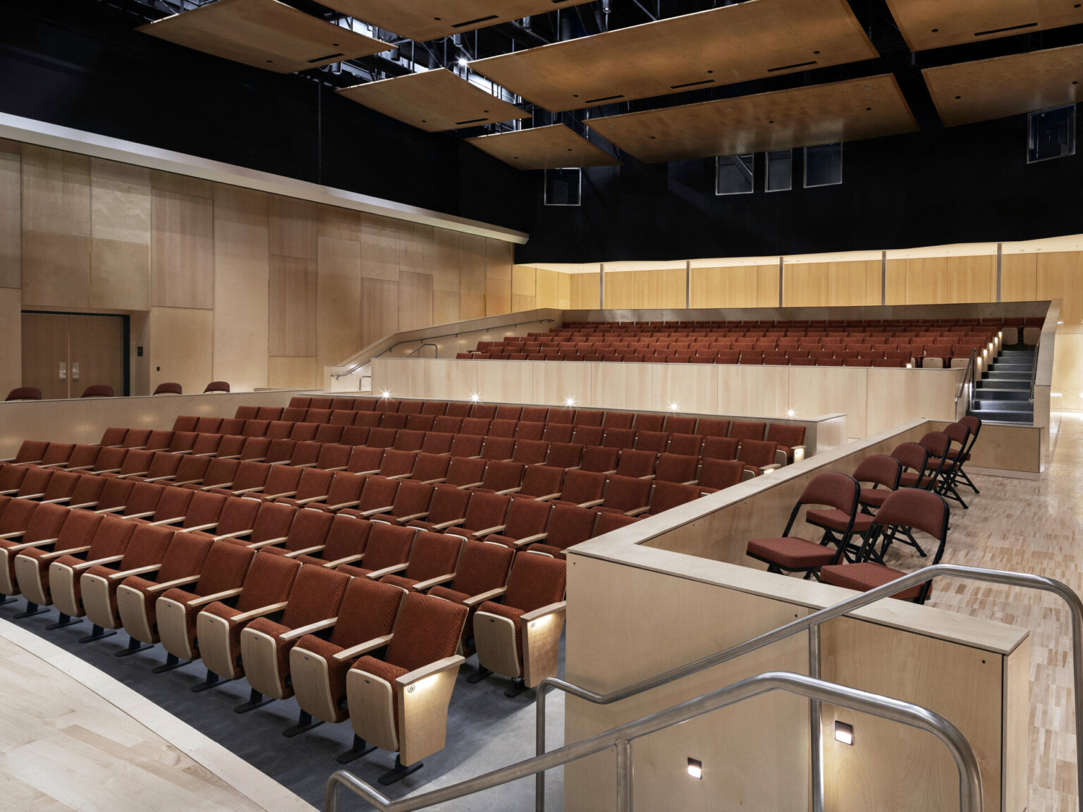 400-seat performance space, blonde wood walls and stage, looking to audience chamber with red seats