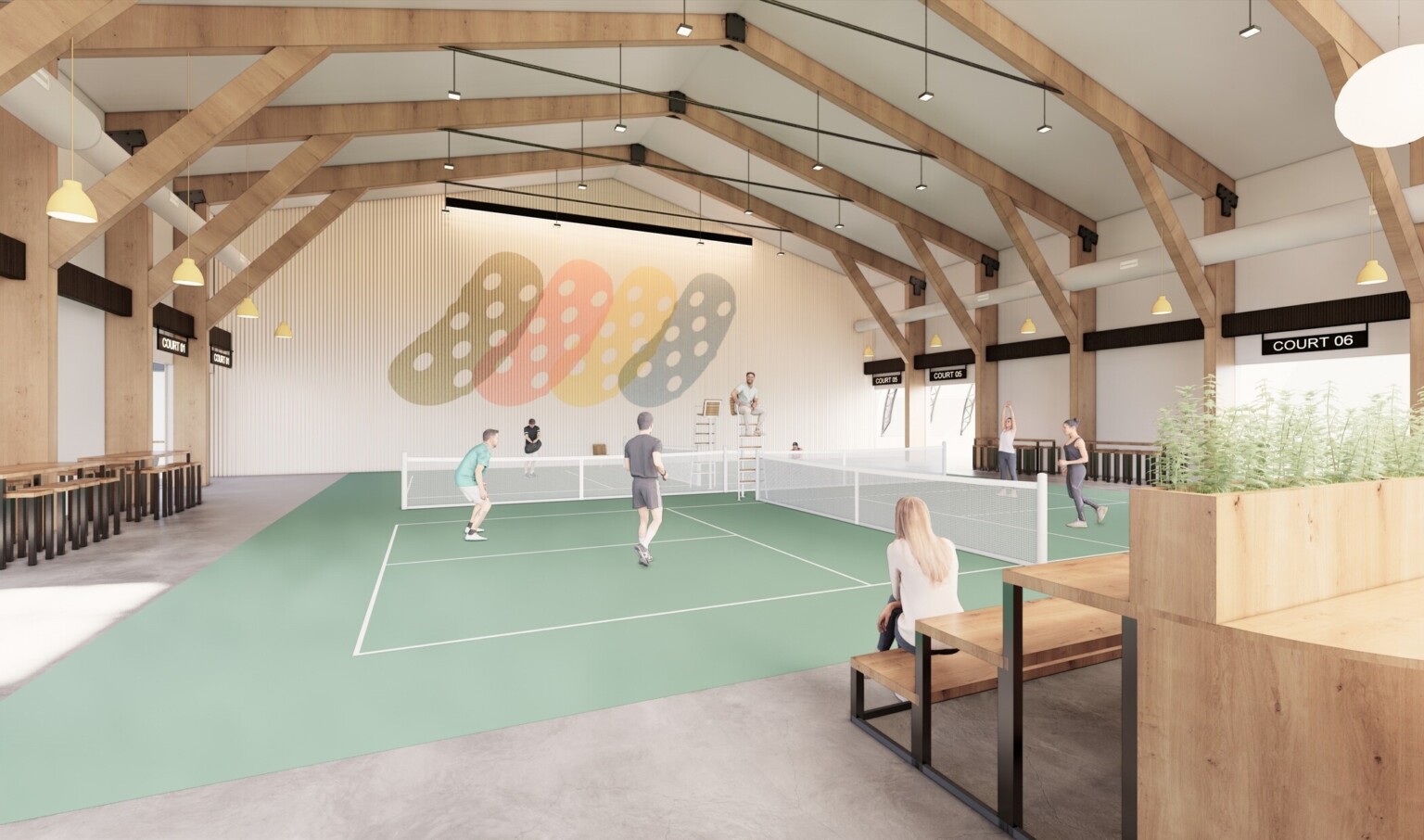 Indoor Pickle Ball court with seating area, open beams, and custom lighting