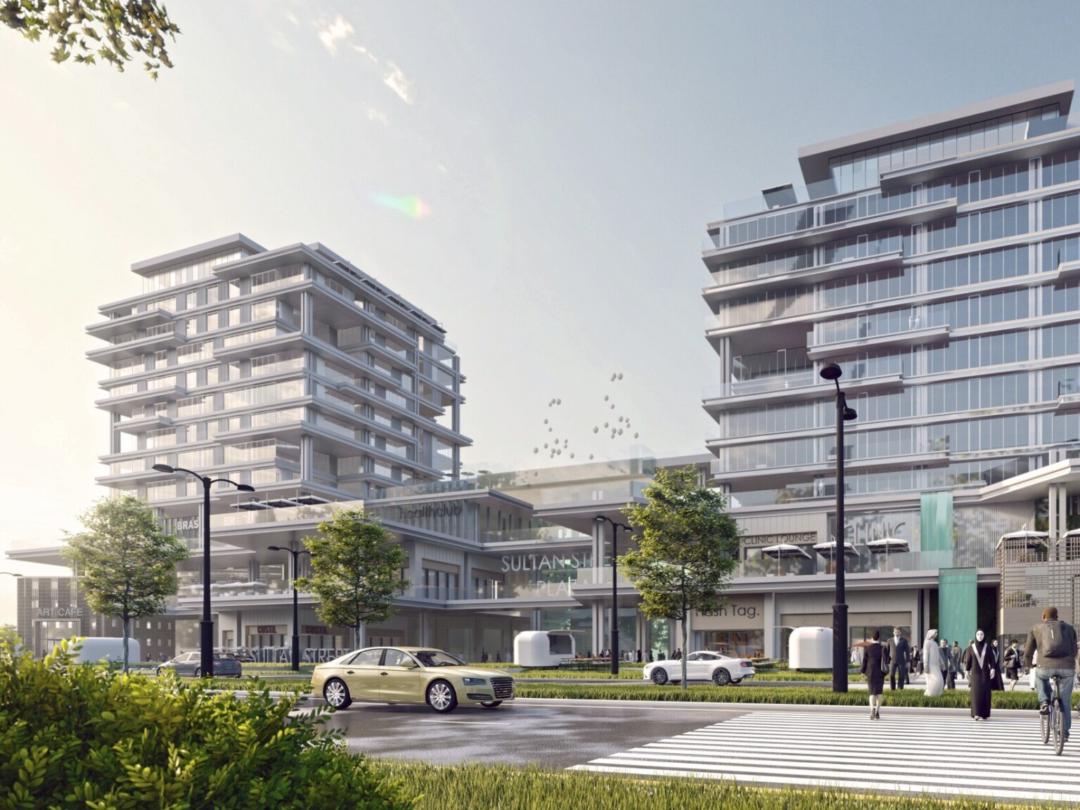 Entrance of Sultan Street Plaza with outdoor dining in front of 3 floor shopping center and floor to ceiling window apartment