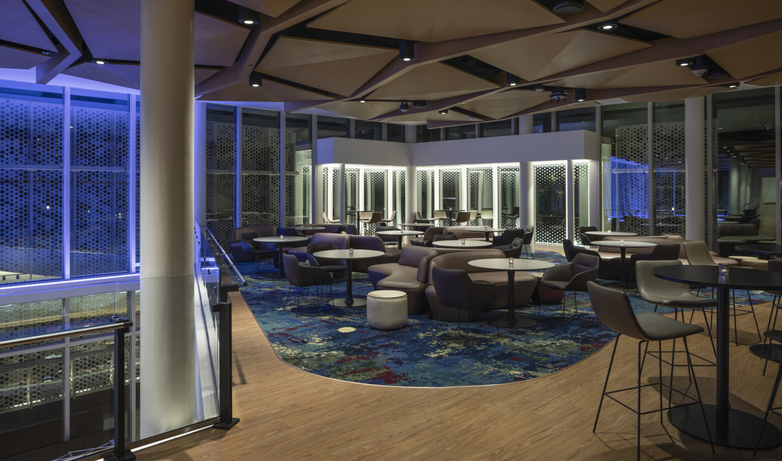 geometrical acoustic ceiling, intimate lounge and bar, cool vibe, blue lights, floor to ceiling windows, mezzanine overlooking lobby
